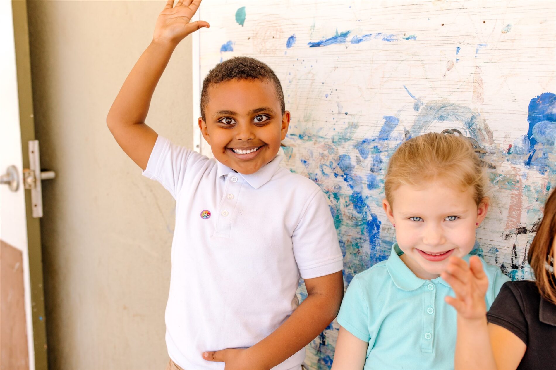 Kavod Charter School smiling students in front of mural