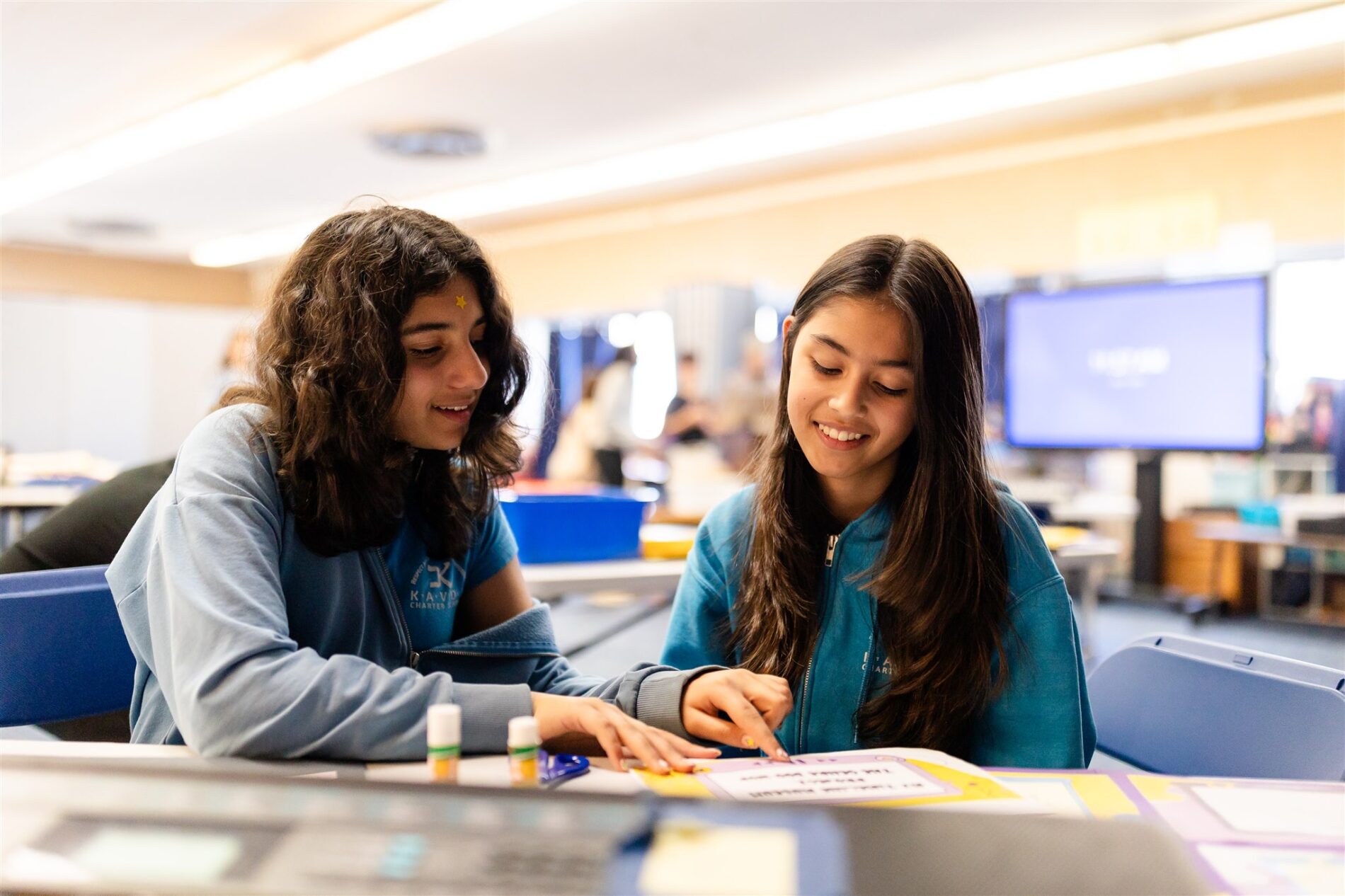 Two Kavod middle school students working together in a brightly lit classroom.