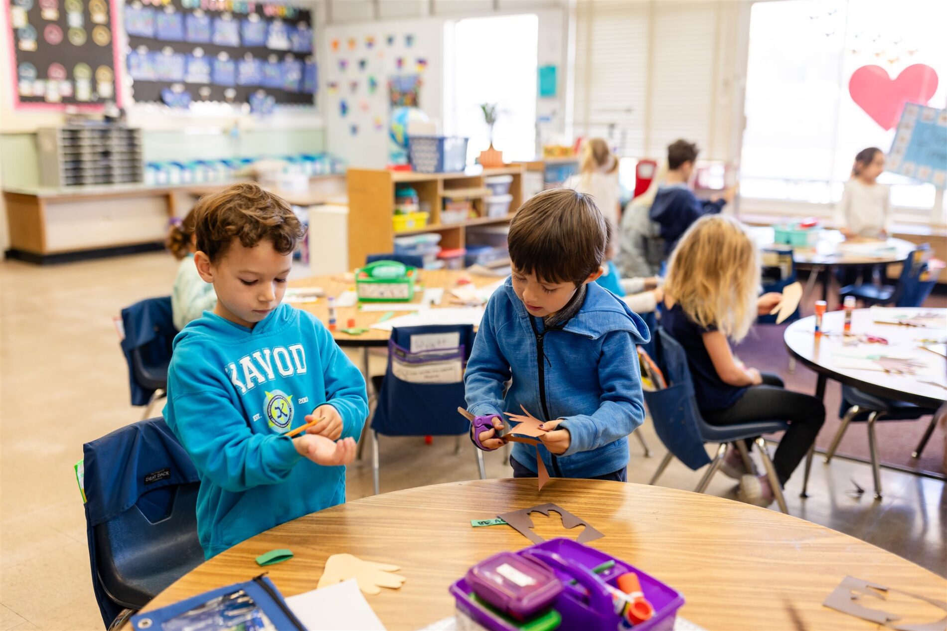 Kavod students work independently in their classrooms, strengthening their hand-eye coordination using scissors.