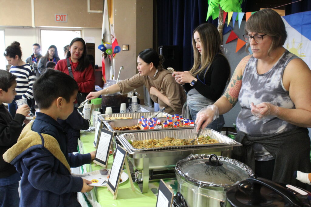 Parents dishing out food to students at Kavod’s Cultural Fair.